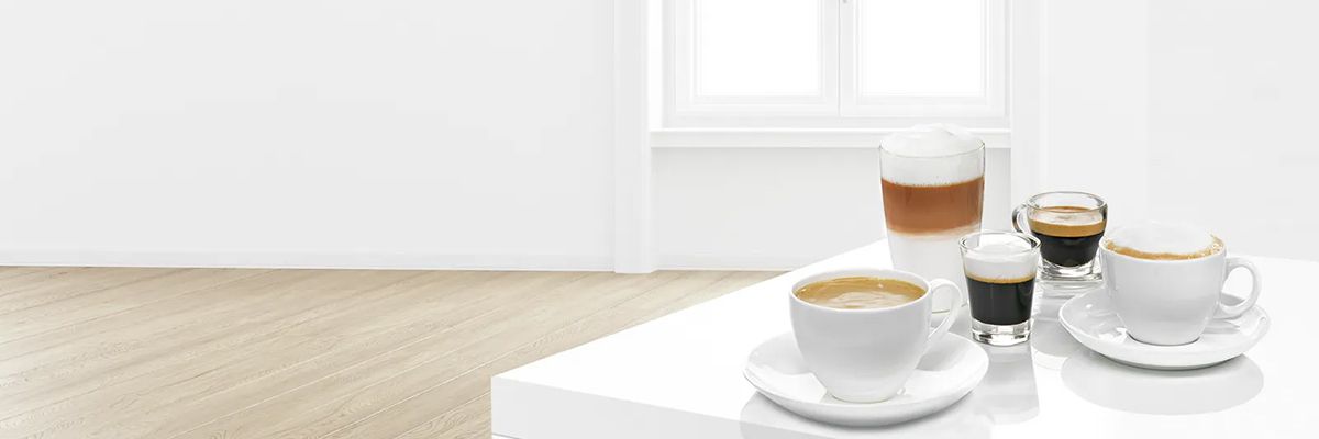 Viele weiße Geschirrteile, darunter Teller, Tassen und Gläser, sind in einer Geschirrspülmaschine eingelagert, während sie gereinigt werden.